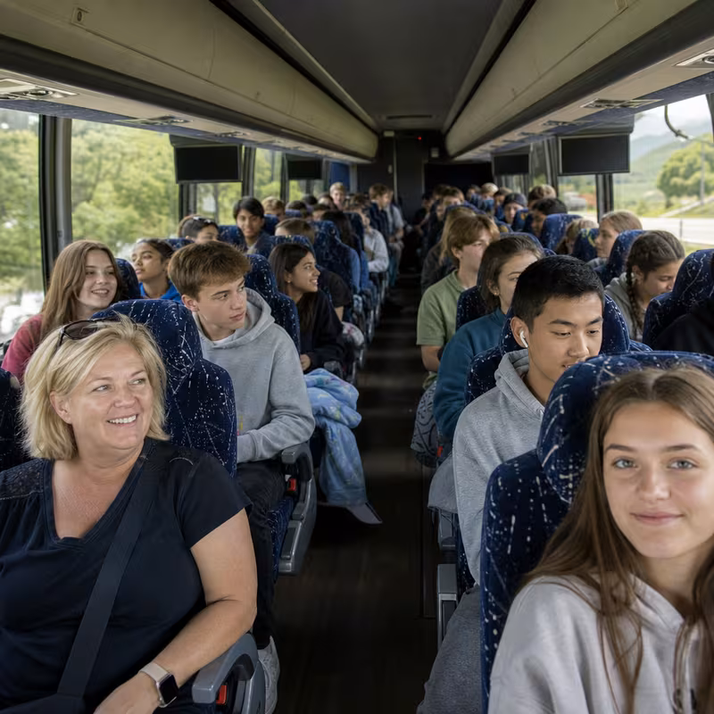 Group boarding a white charter bus for School Transportation transportation in Amarillo