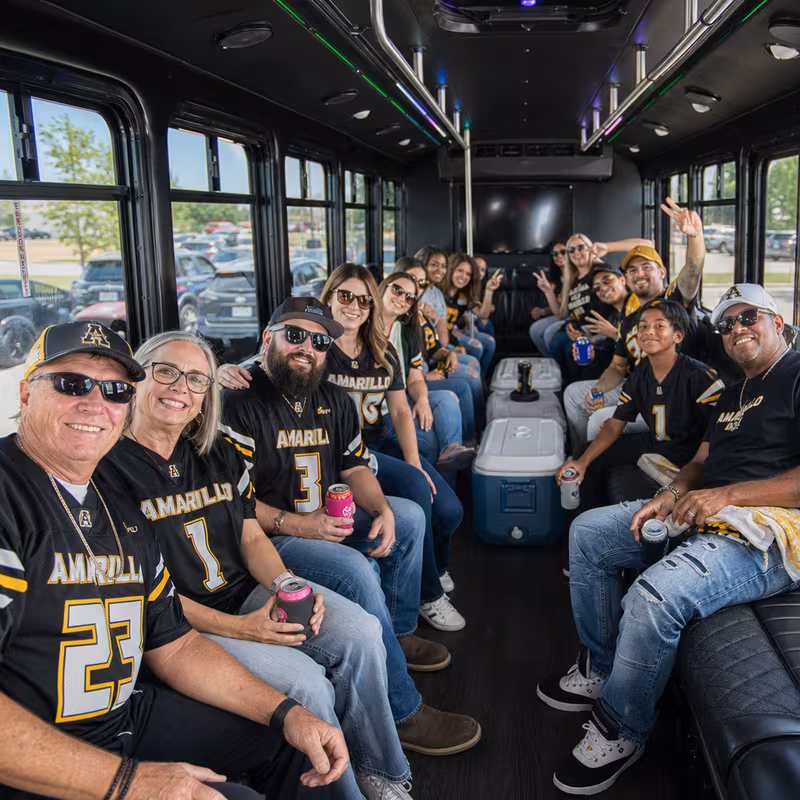Group boarding a white charter bus for Sporting Event Transportation transportation in Amarillo
